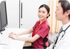 医療事務作業補助者が医師と一緒にパソコンで作業する様子｜日本データー医療事務求人サイト